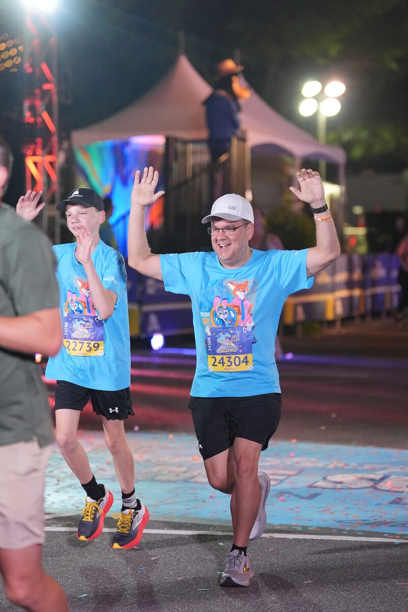 Father and son crossing the 5K finish line with hands up