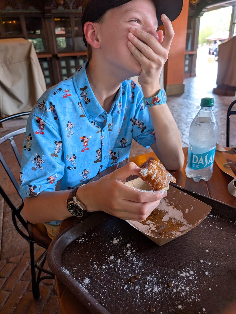 Andrew blowing powdered sugar from a beignet